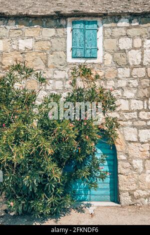 Traditional stone house with blue door and window in Croatia Stock Photo