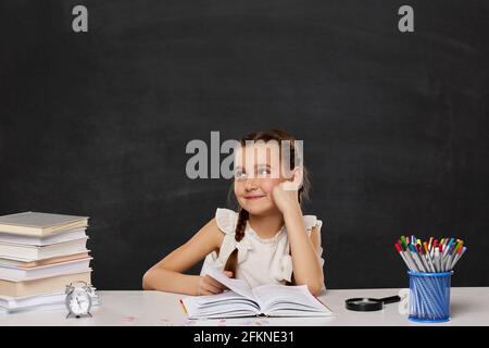 little child girl reading a book in the classroom Stock Photo