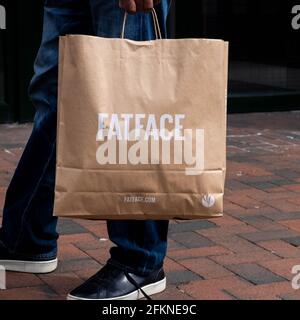 Epsom Surrey London UK, May 02 2021, Man Holding A Brown Paper Fatface Carrier Bag Stock Photo