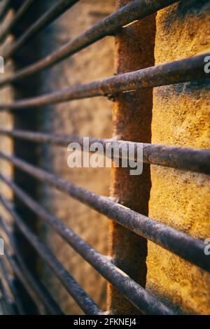 window with a rusty grille with a wrought iron pattern Stock Photo