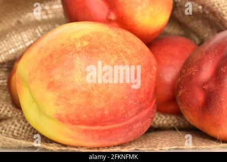 Several juicy organic nectarines in a jute bag, close-up. Stock Photo