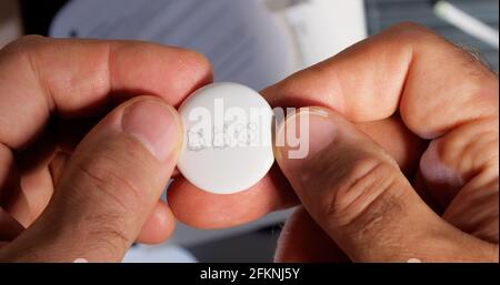 Man pov looking at AirTag with printed emoji Stock Photo