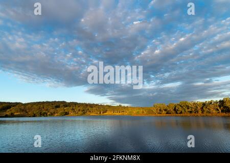 Scenic view of dramatic clouds reflected in Lake Inverell in late afternoon sunlight, Inverell, New South Wales, Australia Stock Photo