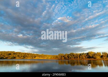 Scenic view of dramatic clouds reflected in Lake Inverell in late afternoon sunlight, Inverell, New South Wales, Australia Stock Photo