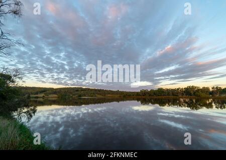 Scenic view of dramatic clouds reflected in Lake Inverell in late afternoon sunlight, Inverell, New South Wales, Australia Stock Photo