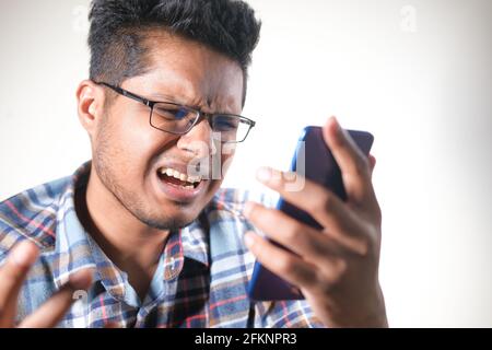 sad young man using smart phone indoor  Stock Photo