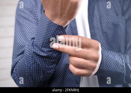 Man buttoning his shirt close up Stock Photo