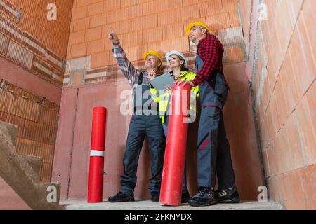 Male construction workers discussing project of building Stock Photo