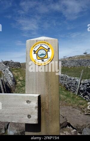 Yellow Round Metal Marker on Gatepost near Grassington on the Dales Way Long Distance Footpath in the Yorkshire Dales National Park, England, UK. Stock Photo