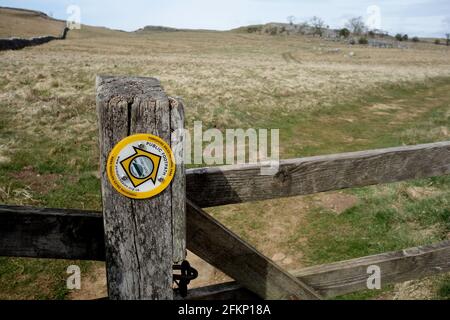 Yellow Round Metal Marker on Gatepost near Grassington on the Dales Way Long Distance Footpath in the Yorkshire Dales National Park, England, UK. Stock Photo