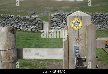 Yellow Round Metal Marker on Gatepost near Grassington on the Dales Way Long Distance Footpath in the Yorkshire Dales National Park, England, UK. Stock Photo