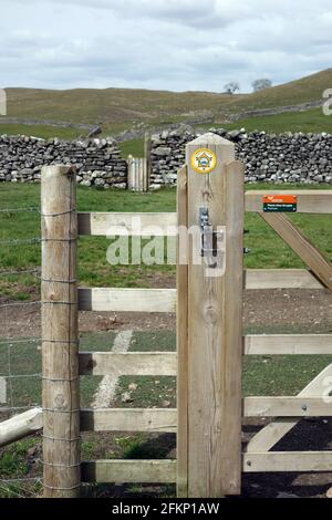 Yellow Round Metal Marker on Gatepost near Grassington on the Dales Way Long Distance Footpath in the Yorkshire Dales National Park, England, UK. Stock Photo