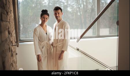 Portrait of young couple in spa resort, looking at camera on staircase. Stock Photo