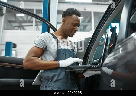 Male mechanic using laptop, car service Stock Photo