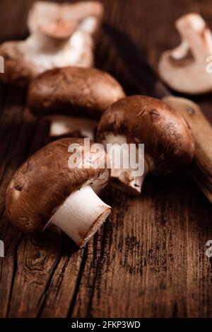 Cremini mushrooms on textured wood background. Baby portobello. Closeup. Selective focus Stock Photo