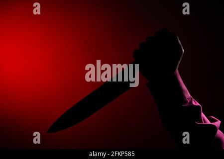 Murderer with big knife in hand of scary crime scene, Silhouette style Stock Photo