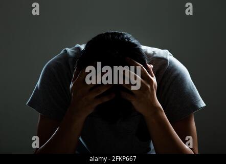 Sad and depressed man covering face - Feeling depressed background concept Stock Photo
