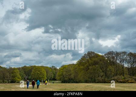 Chorleywood, UK.  3 May 2021.  UK Weather: People walking under ominous grey clouds gathering over Chorleywood Common, Hertfordshire on May’s early Bank Holiday Monday.  The forecast is for conditions to worsen with heavy rain and strong winds towards the end of the day.  Credit: Stephen Chung / Alamy Live News Stock Photo