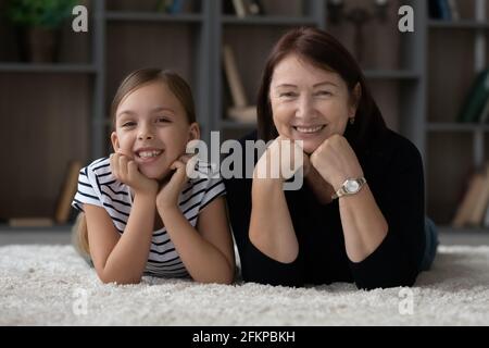 Portrait of happy elderly grandmother and granddaughter relaxing Stock Photo