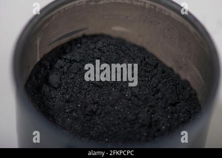 Activated charcoal powder for facial mask. Natural beauty treatment and spa. Beauty concept. Close up. Selective focus. Stock Photo