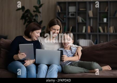 Happy three generations of women relax using gadgets Stock Photo