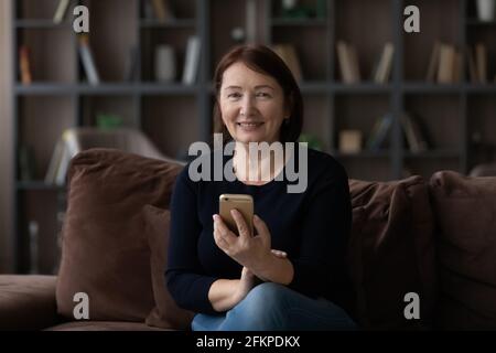 Portrait of smiling elderly woman use cellphone Stock Photo