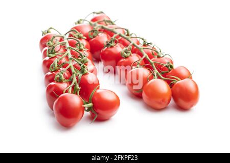 Fresh red cherry tomatoes. Small tomatoes on branch isolated on white background. Stock Photo