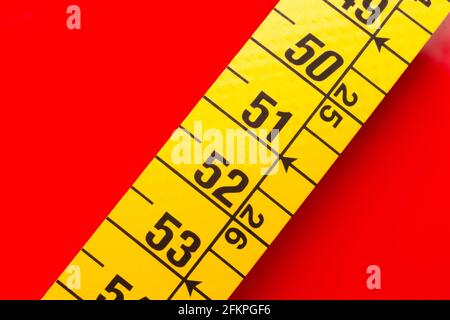 Yellow tape measure for measuring perimeters of objects; tailor's and dressmaker's tape for taking body measurements.