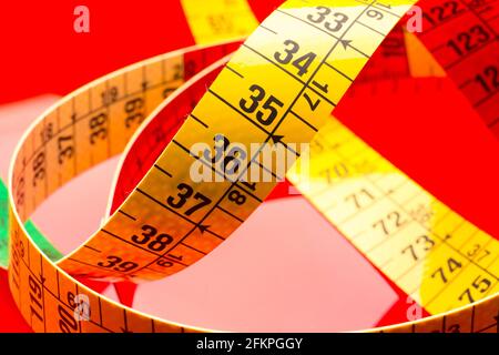Yellow tape measure for measuring perimeters of objects; tailor's and dressmaker's tape for taking body measurements.
