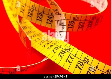 Yellow tape measure for measuring perimeters of objects; tailor's and dressmaker's tape for taking body measurements.