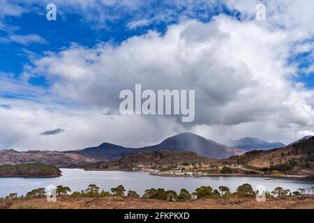 SHIELDAIG WESTER ROSS HIGHLANDS SCOTLAND VIEW OVER LOCH SHIELDAIG TO THE VILLAGE HOUSES AND TREE COVERED ISLAND Stock Photo