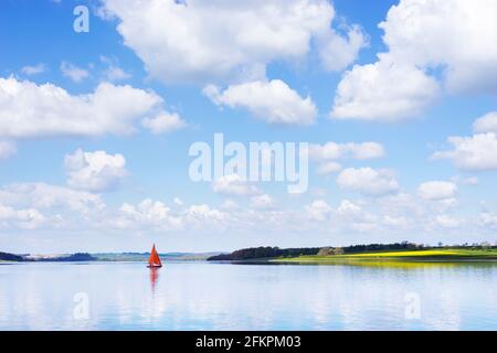 Rutland water reservoir - One Sailing boat or One yacht with red sails on Rutland water reservoir Oakham Rutland England UK GB Europe Stock Photo