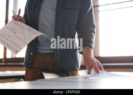 Cropped shot of unrecognizable college professor laying out exam papers in school auditorium lit by sunlight, copy space Stock Photo