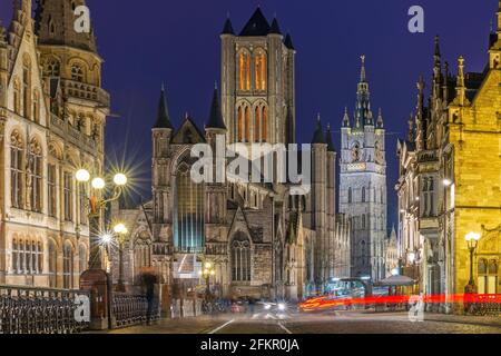 Ghent (Gent) city center at night with blurred motion of people and transportation vehicles with Saint Bavo Cathedral and belfry, Flanders, Belgium. Stock Photo