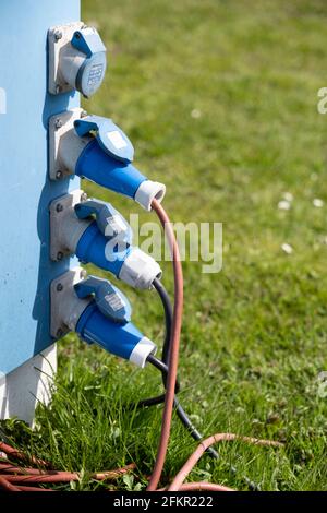 A vertical row of earthed power sockets on a campsite to supply the campers, caravans and tents with electricity Stock Photo