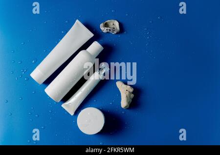 White plastic containers to represent different cosmetics for the care of the face, hands, eyelids, eyes, body, flat layout, copying space Stock Photo