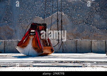 Old rusty grab for loading of clinker cargo in port. Industrial heavy machinery detail view Stock Photo