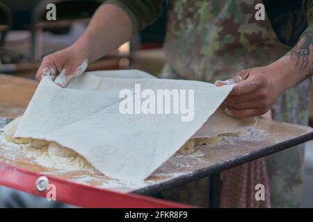 Man laying cover over dough balls outside in a food market Stock Photo