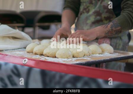 Man placing pizza dough balls in order at a market stall in London Stock Photo