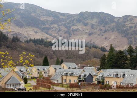 New houses at St Fillans with rocky hills in the background. Stock Photo