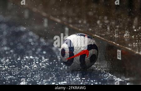 A match ball is seen behind the advertising hoardings as the heavy rain falls during the Premier League match at The Hawthorns, West Bromwich. Issue date: Monday May 3, 2021.