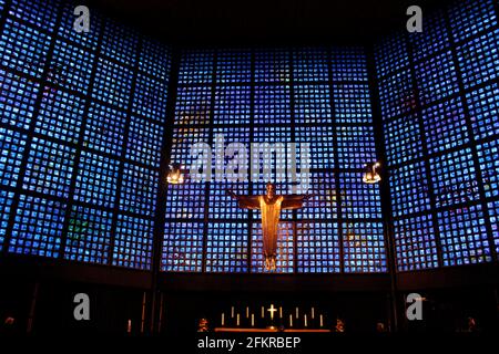 Interior of Kaiser Wilhelm Memorial Church in Belin, Germany with blue and purple glass and statue of Jesus above the altar Stock Photo