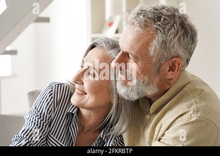 Happy older mature couple hugging, bonding, thinking, dreaming of good future. Stock Photo