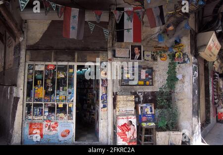 Front shop with Syrian flag hanging and president poster in Al-Hamidiyah Souq, Damascus, Syria Stock Photo