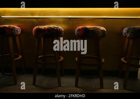 Colourful empty barstools under golden glowing light Stock Photo