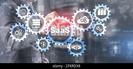 SaaS Software as a Service concept with hand pressing text. Stock Photo