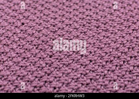 Knitted fabric pearl woolen background, close-up. The structure of the fabric with a natural texture. Fabric background. Knitted woolen background Stock Photo