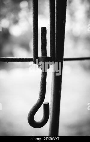 Vertical shot of an old hook in grayscale Stock Photo