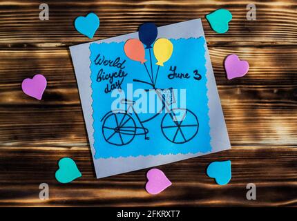 Step by step tutorial on making a colored cardboard greeting card. How to make a paper card with bike. DIY concept. Photo instruction. World bicycle d Stock Photo