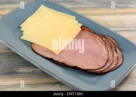 Swiss cheese and ham slices on blue serving lunch plate Stock Photo